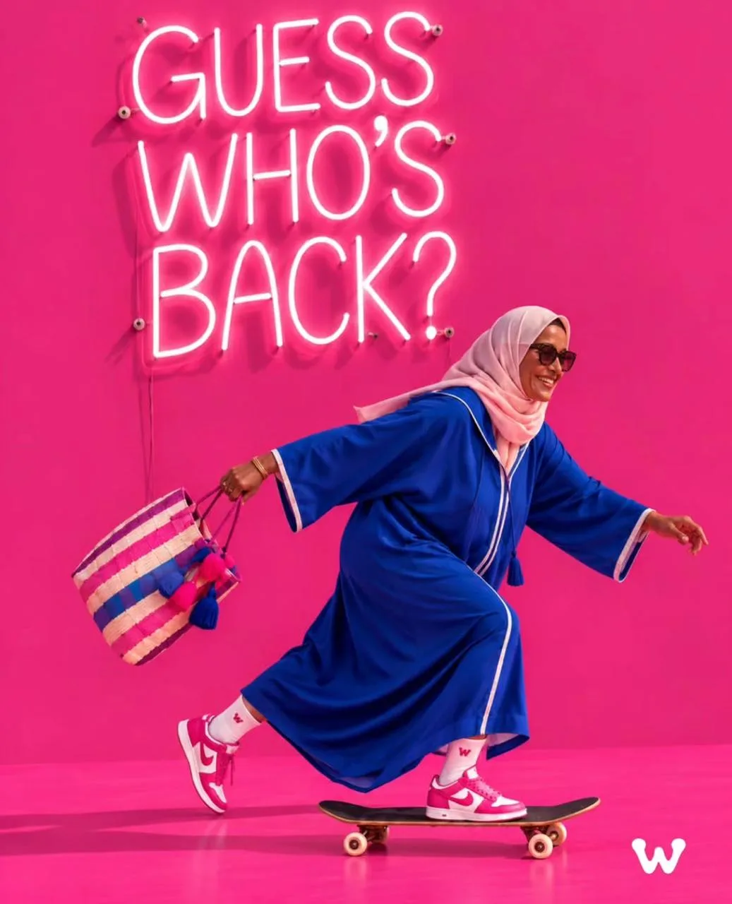 Une dame en djellaba bleue et baskets roses file sur un skateboard, panier au bras, devant un néon « Guess who's back? »